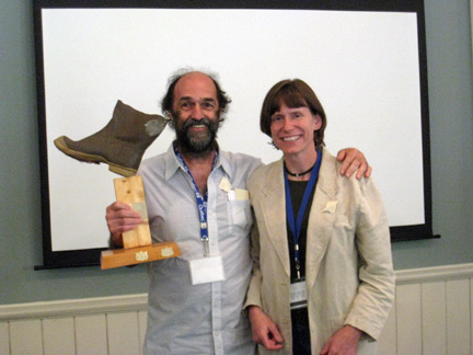 Yves Mailhot is presented with the Soggy Boot Award by Christine Lipsky on the right. The Soggy Boot Award is given to the person who has the funniest presentation during the meeting.