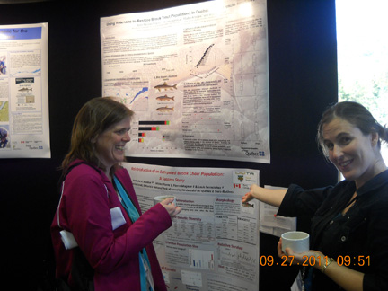A view of the Poster Session. Nathalie Brodeur shows off the poster of her research to Kathryn Collet.