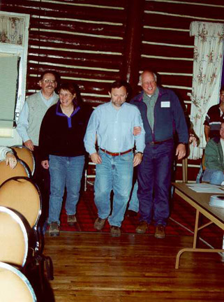 Incoming 2000-01 President Forrest Bonney is escorted up the aisle by past presidents Brandon Kulik, Joan Trial, and Fred Kircheis